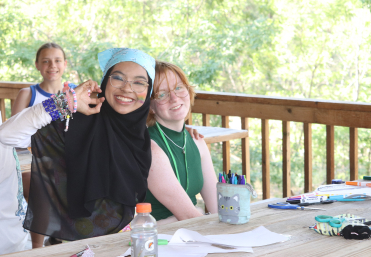 Camp Outdoors attendees at a table eating and making crafts