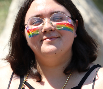 Teen girl with rainbows painted on her cheeks