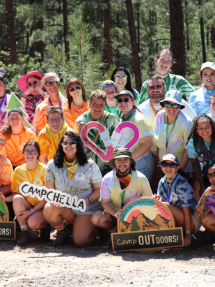 Group of Camp Outdoors attendees holding a Campchella sign