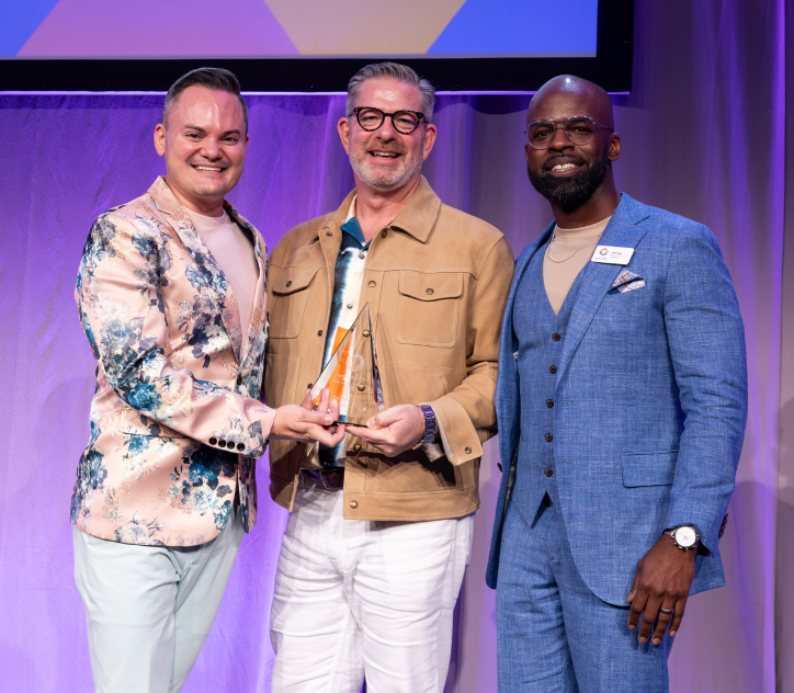 Three one•n•ten leaders accepting an award on stage