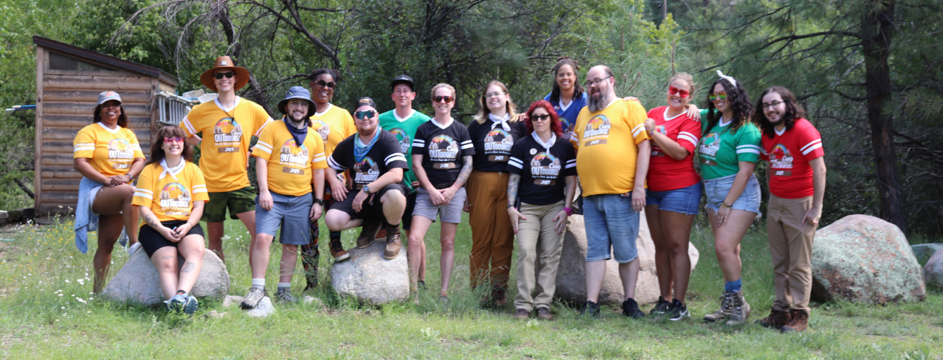 Group of people wearing Camp Outdoors shirts posing in the forest