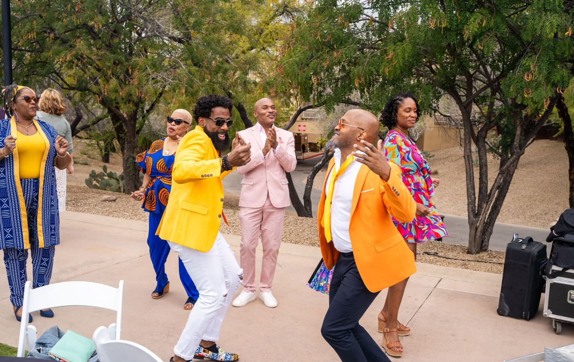 Black LGBTQ adults dancing at an outdoor fundraiser