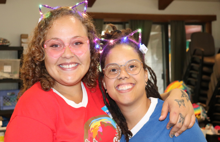 Two females wearing glowing cat ears in their hair