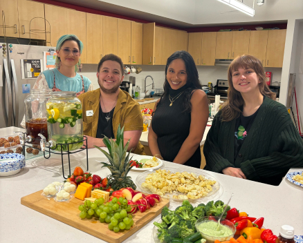 one•n•ten members posing in front of fresh food boards