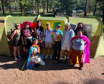 Group of LGBTQ youth standing in front of a pitched tent