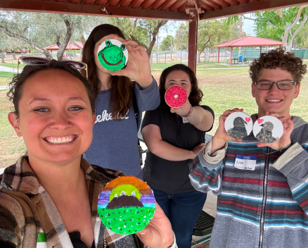 Group of youth members holding up their self-painted drink coasters